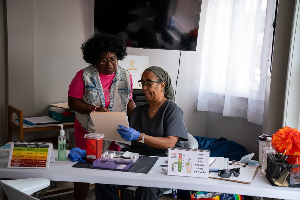 Volunteer nurse and social worker discussing a patient
